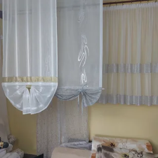 Powieszone na karniszach białe firany gotowe na wystawie