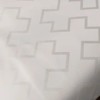 Jasna tkanina ekri z subtelnym wzorem geometrycznych krzyży