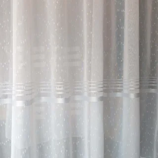 Zbliżenie na srebrne pasy u dołu białej firanki haftowanej